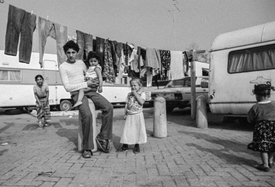 853659 Portret van een Roma-jongen met enkele kleine kinderen in het tijdelijke woonwagenkamp in de Voorveldsepolder te ...